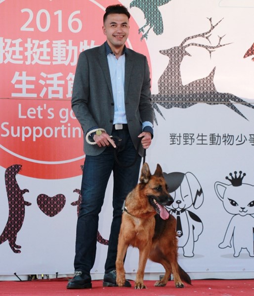 Male model holding a dog handsomely.